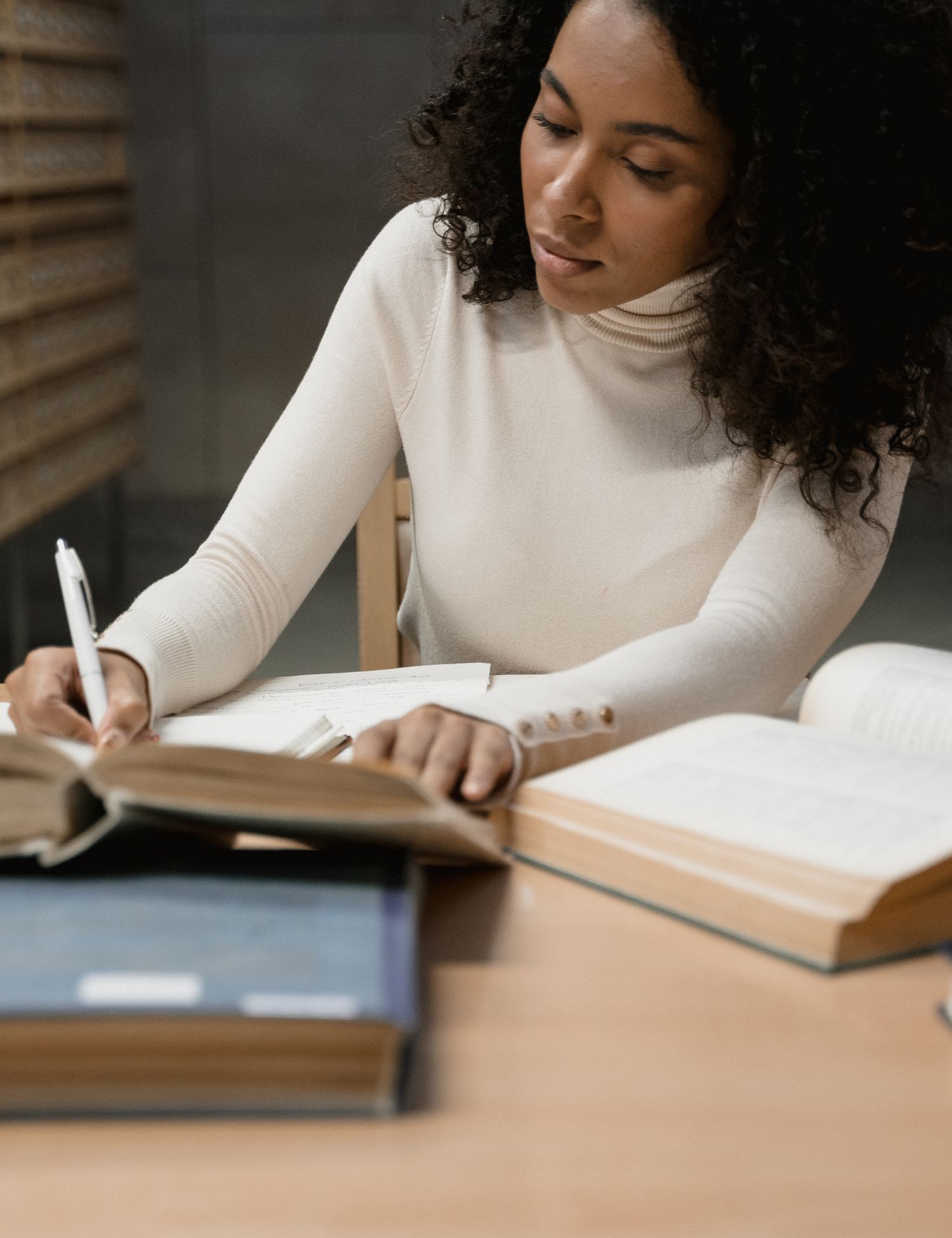 woman writing in notebook at desk